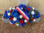 Gerbe de fleurs déposée au pied du monument aux morts .